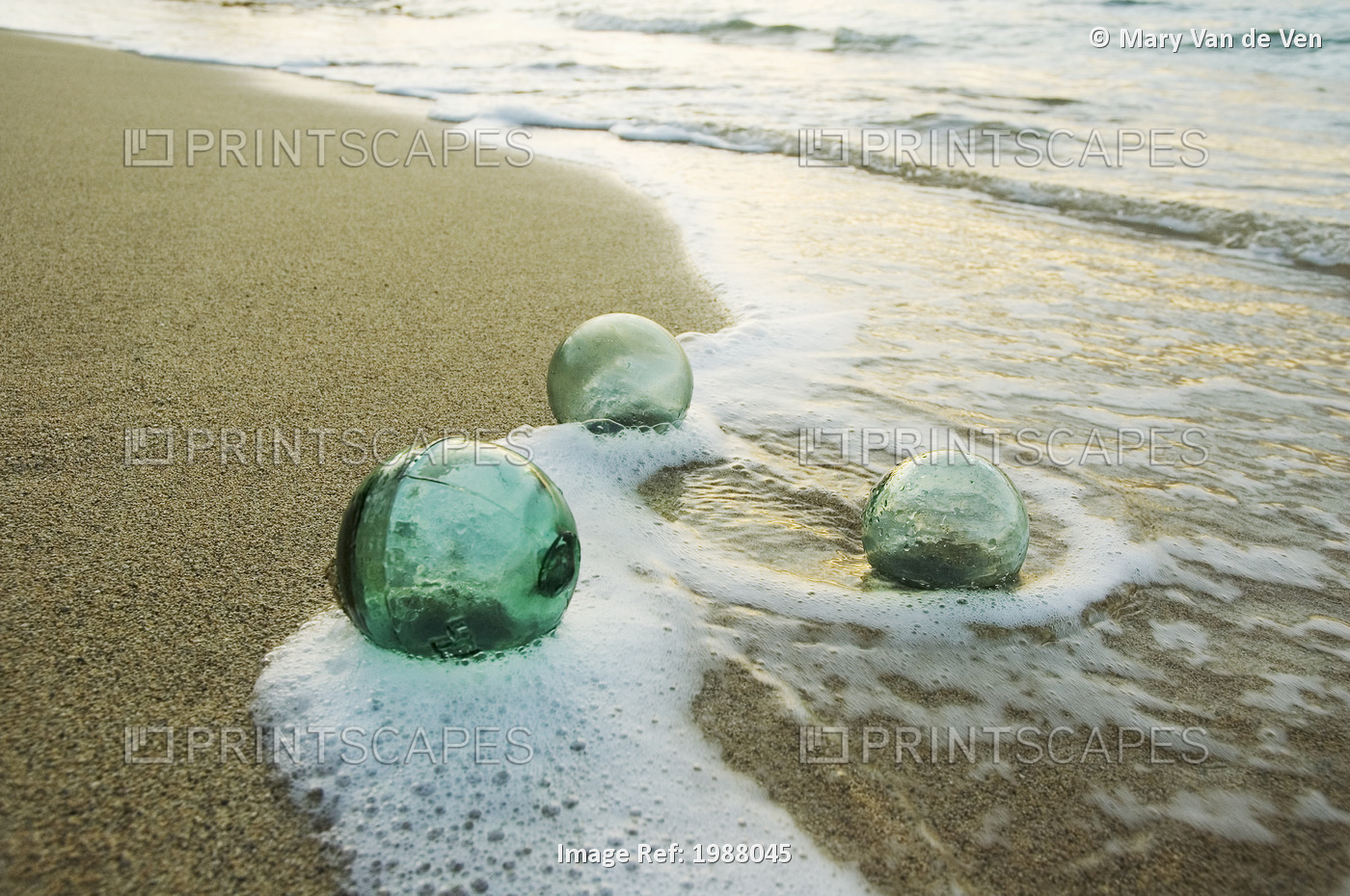 Three Glass Fishing Floats Roll On The Sandy Shoreline With Ripples Of Water ...