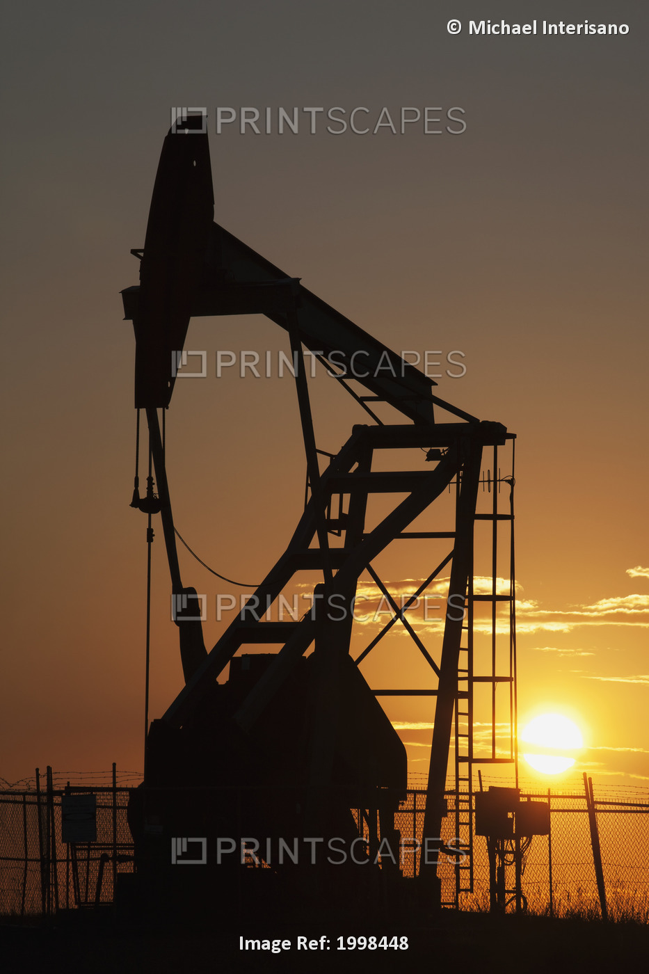 Silhouette Of Pumpjack With The Orange Glow Of The Sun Rising; ...