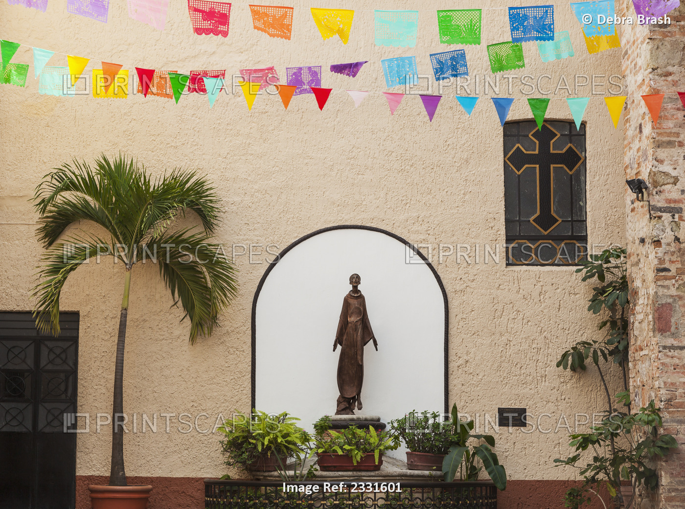 A sculpture of san francisco de assisi is sheltered by the church of our lady ...