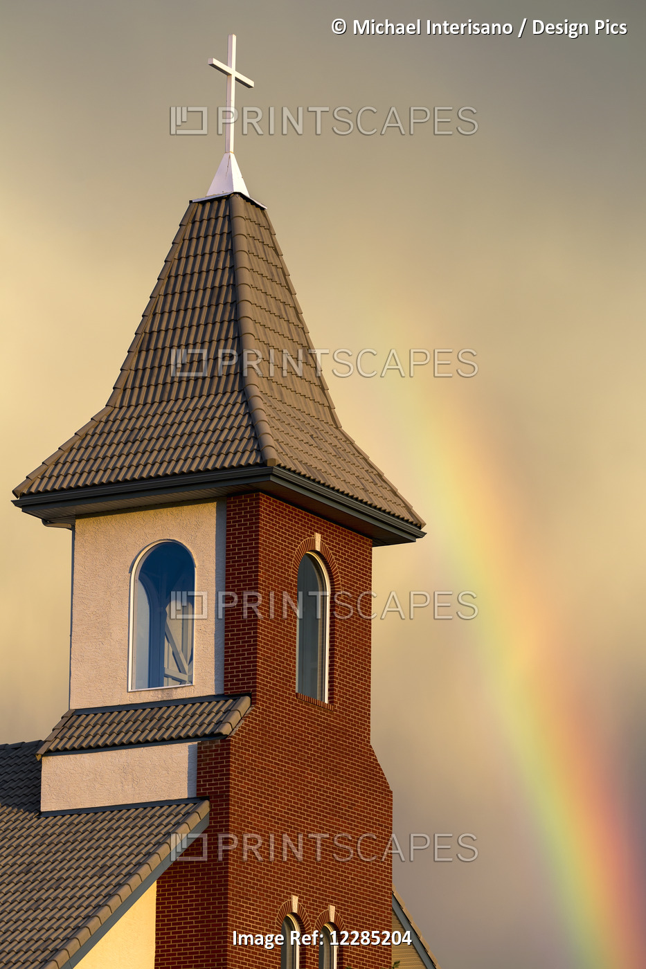Church Steeple With Orange Glow From The Sunset And Rainbow In The Sky; ...