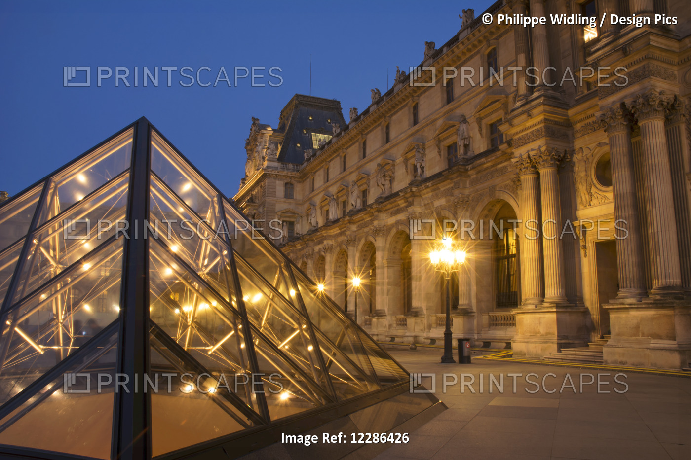 Le Louvre Palace Buildings And Pyramids At Night In Golden Light; Paris, France