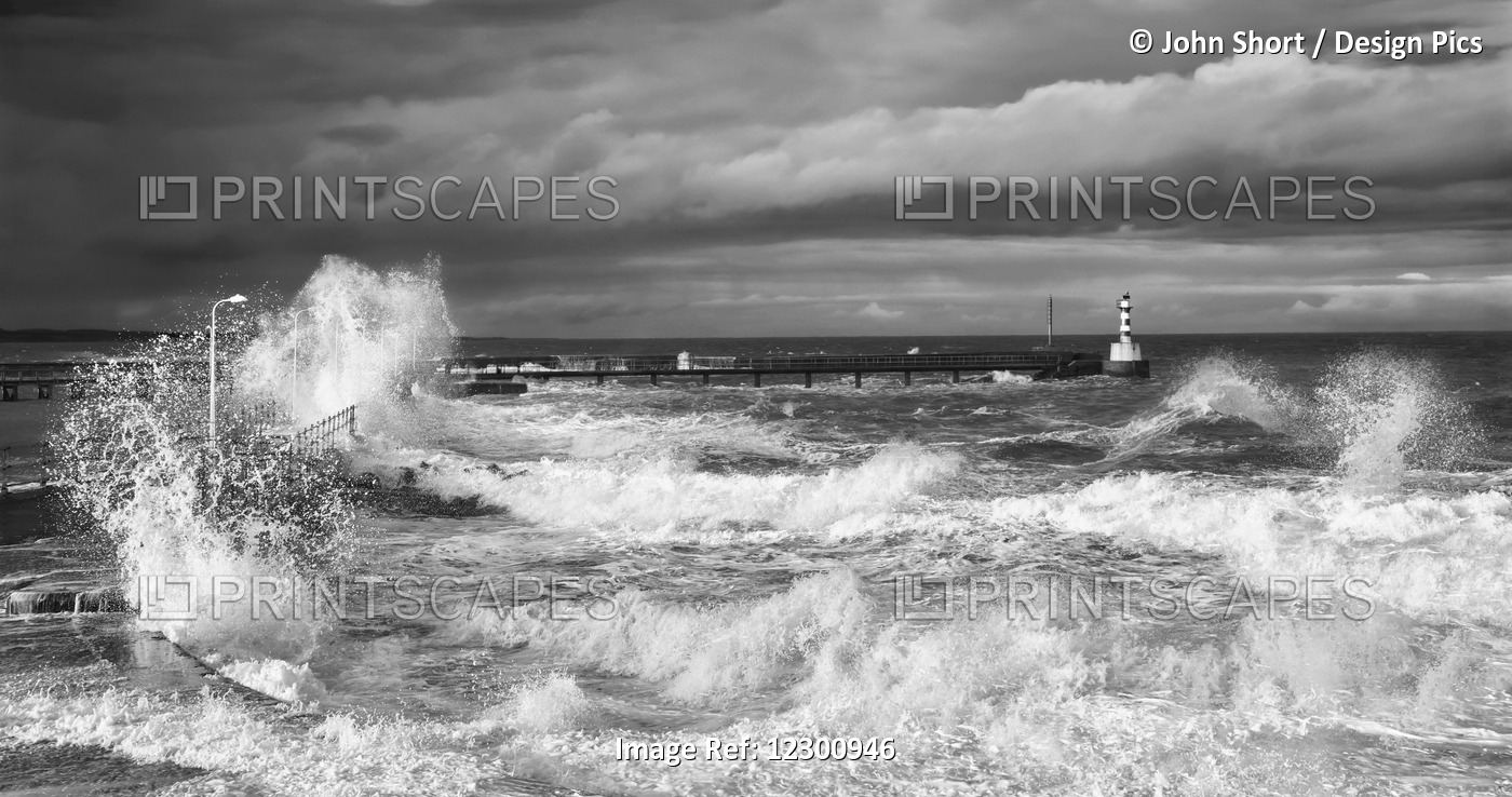 Waves Crashing Along The Coast With A Small Lighthouse At The End Of A Pier; ...