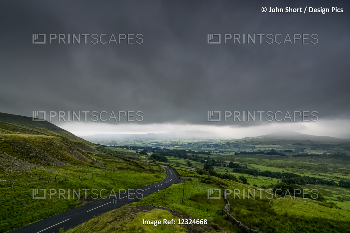 Dark Storm Clouds Over A Lush, Green Landscape And Road; North Yorkshire, ...
