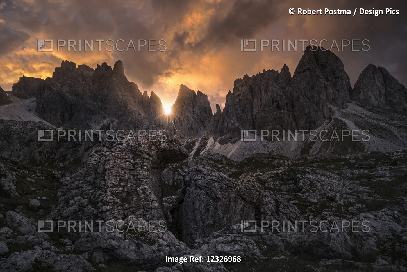A Sunstar Shines Through The Dolomite Mountains At Sunset Near Cortina; Italy