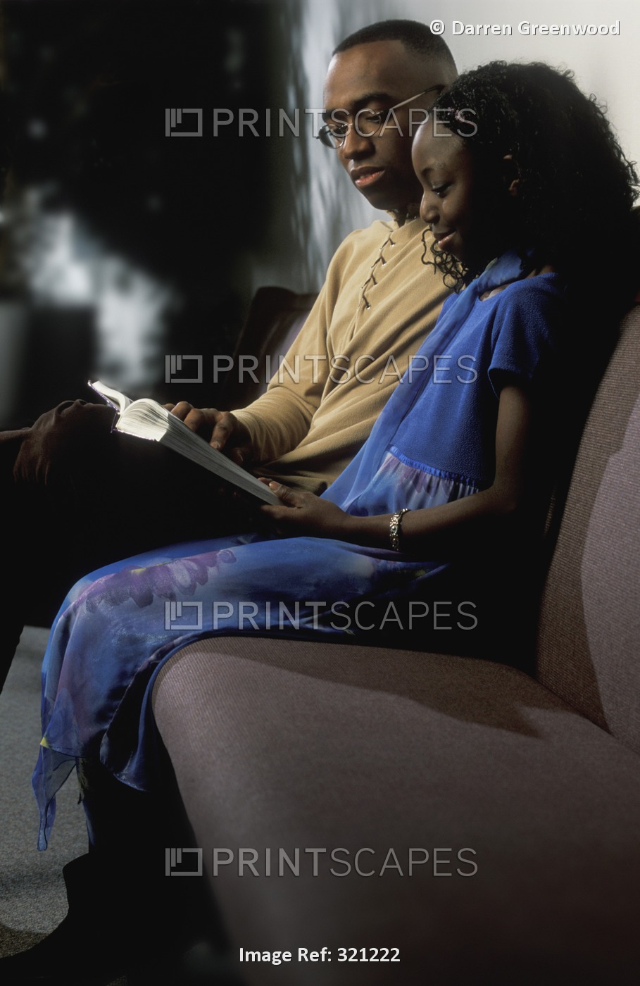 Man And Girl Reading Book On Couch
