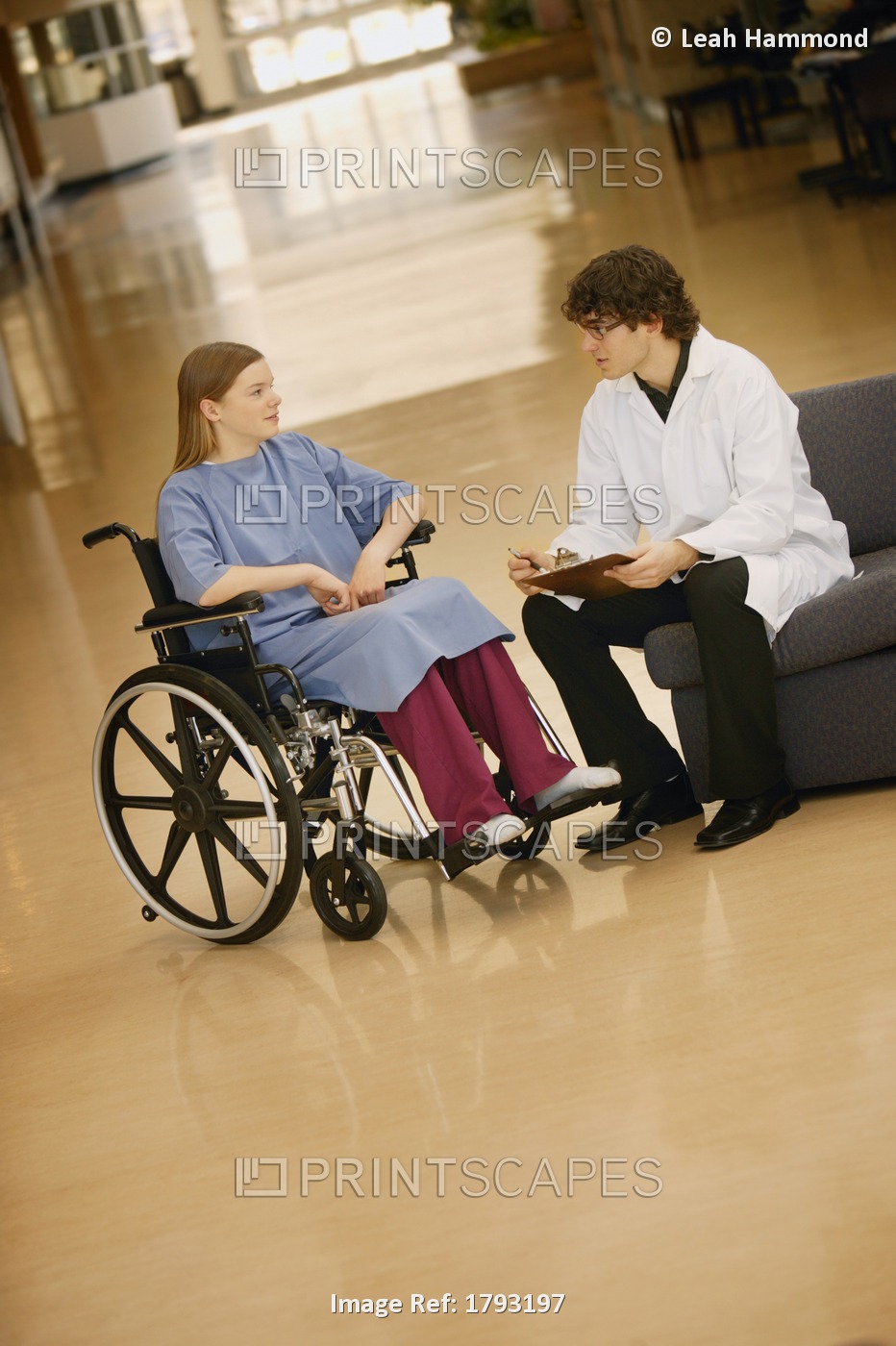 Young Woman In Wheelchair Consulting With Doctor