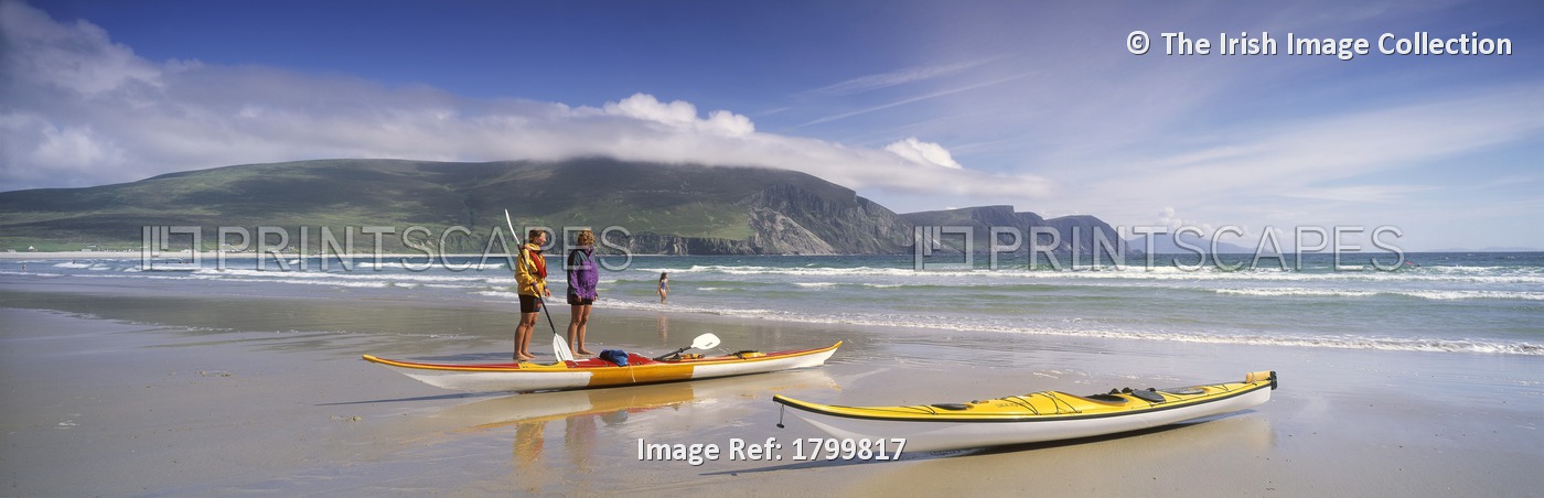 Keel Bay, Achill Island, County Mayo, Ireland; Two People Standing Near Canoes