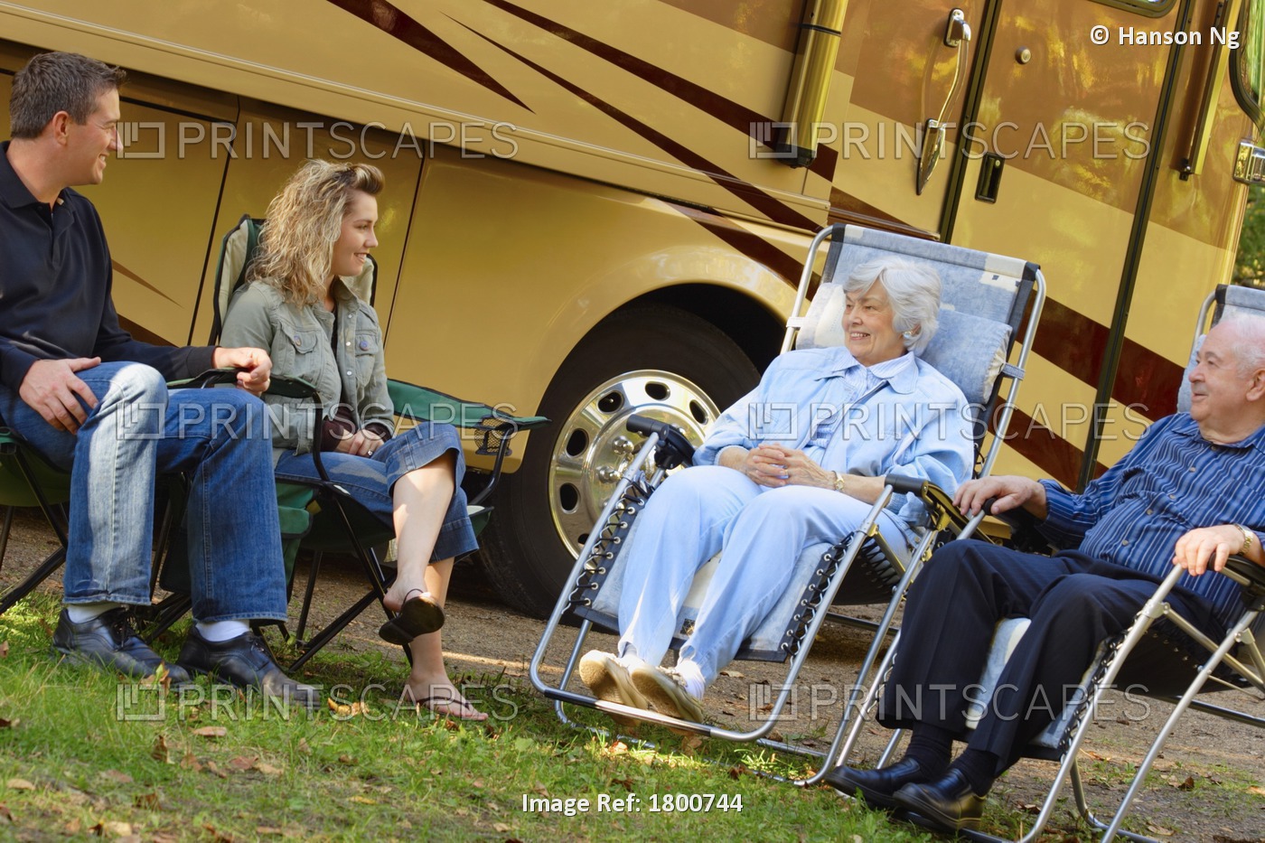 Couples Siting On Lawn Chairs Outside Motor Home