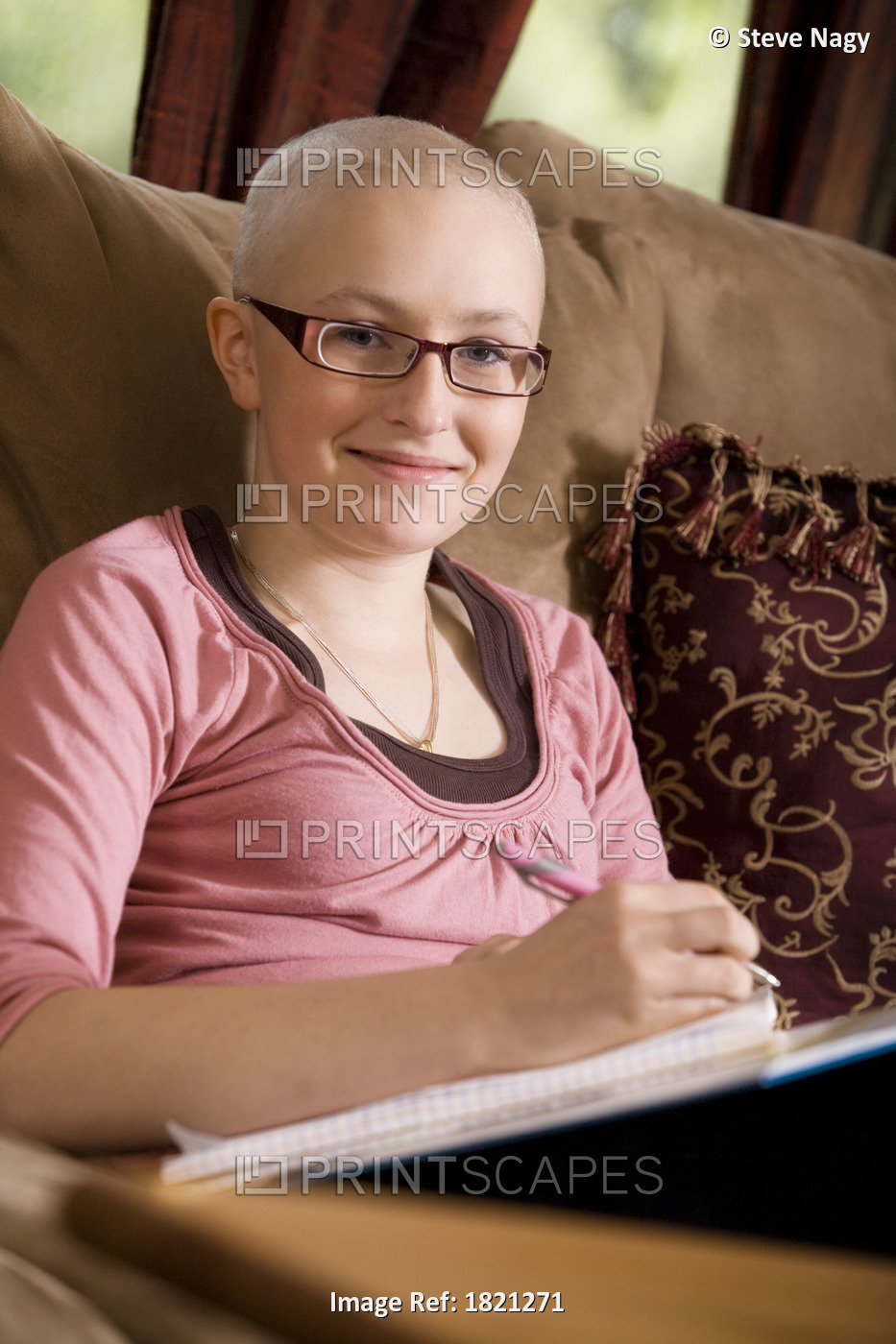 Girl with hair loss from cancer treatment doing homework