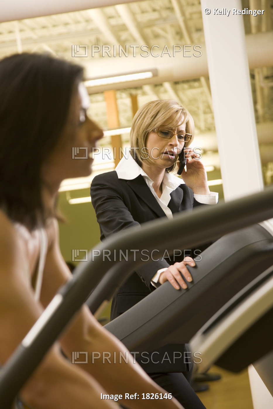 Businesswoman Using Cell Phone On Treadmill