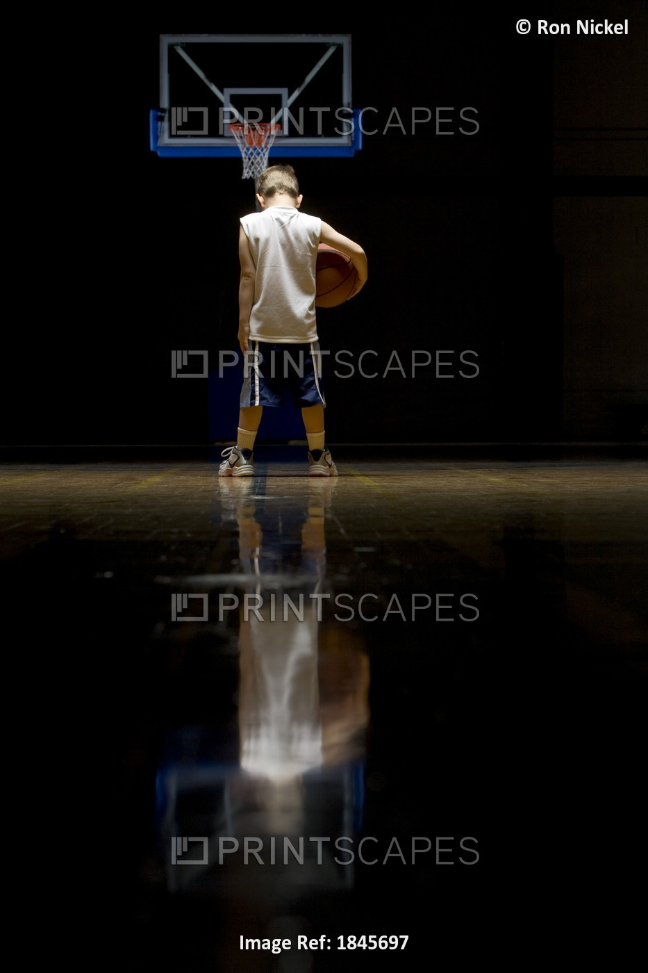 Young Boy Standing On Basketball Court Looking Solemn