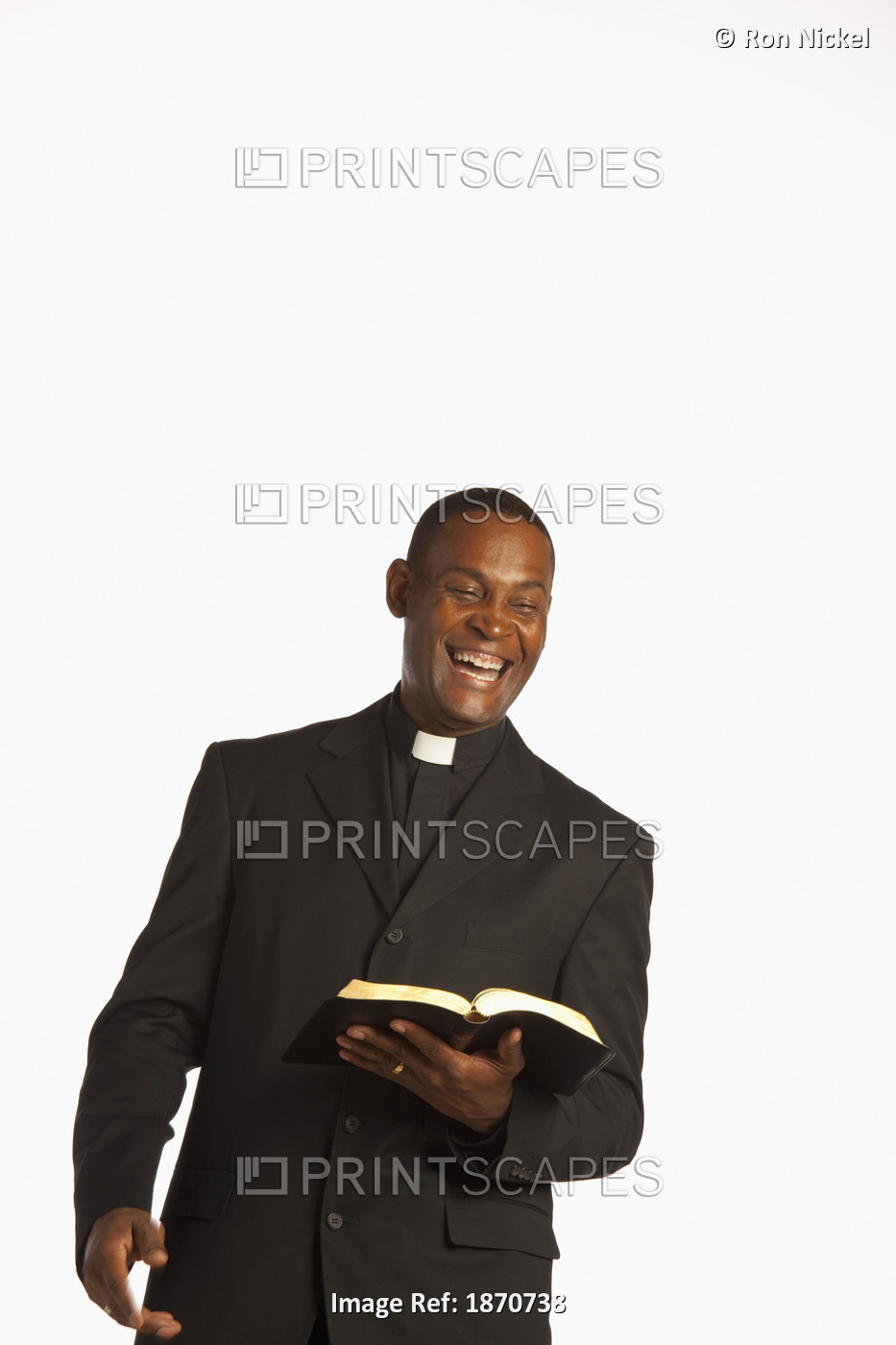 A Man Wearing A Clerical Collar And Laughing While Holding An Open Bible