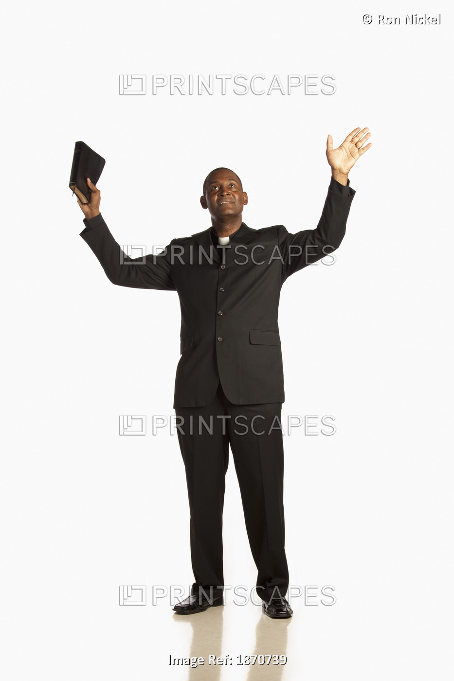 A Man Wearing A Clerical Collar And Holding His Bible Up With Hands Raised And ...