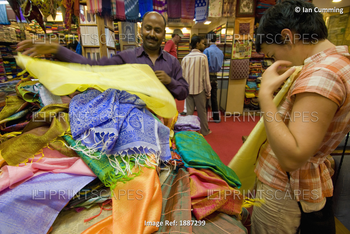 Woman Being Shown Fabrics By Salesman In A Shop