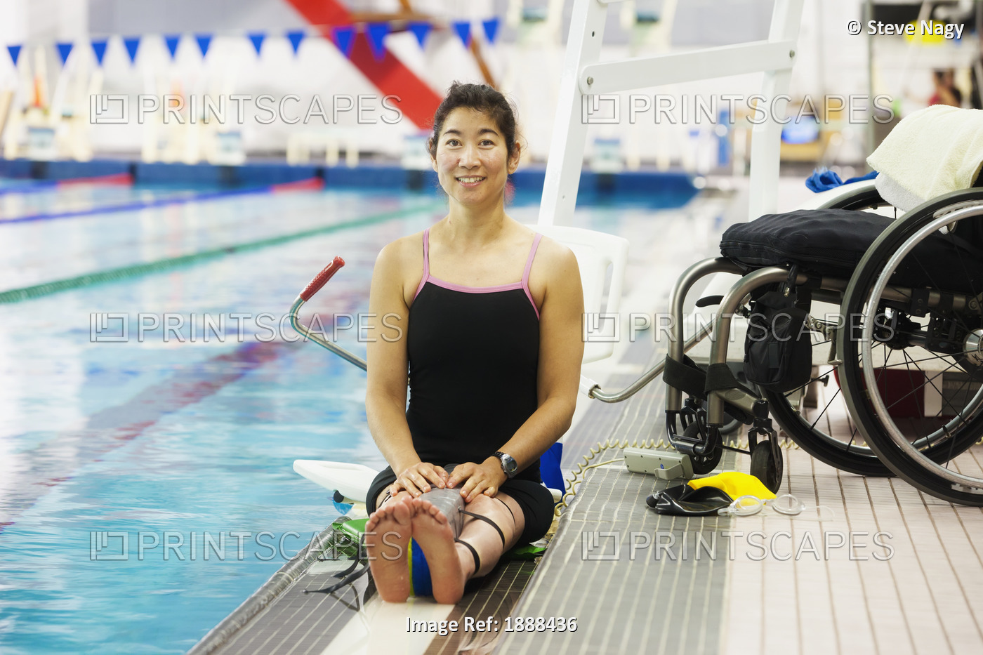 A Paraplegic Woman Sits At The Edge Of A Swimming Pool On A Lift Beside Her ...