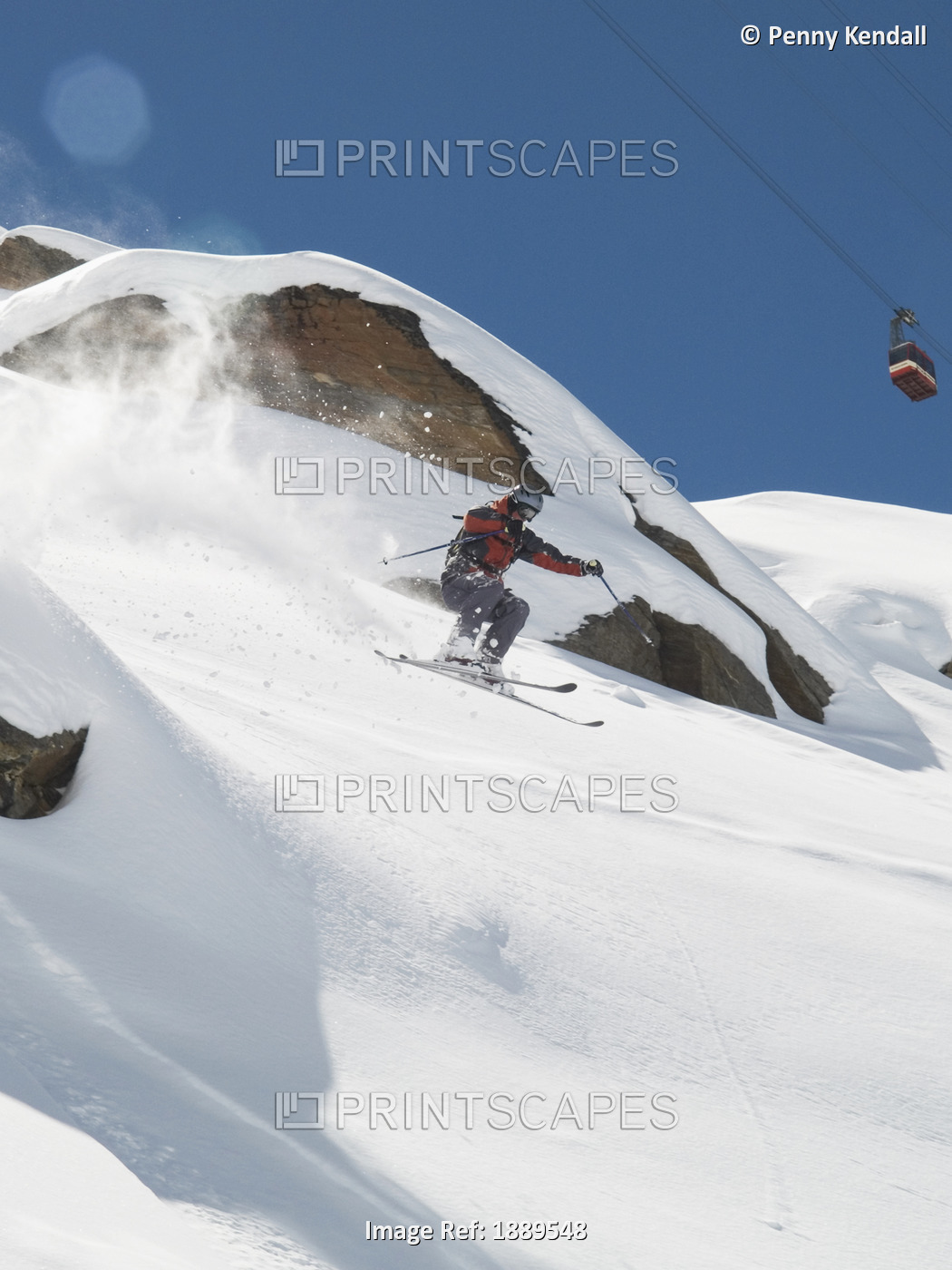 Helmeted Free-Rider Skis Off Piste And Makes A Big Jump Down Onto Fresh Powder