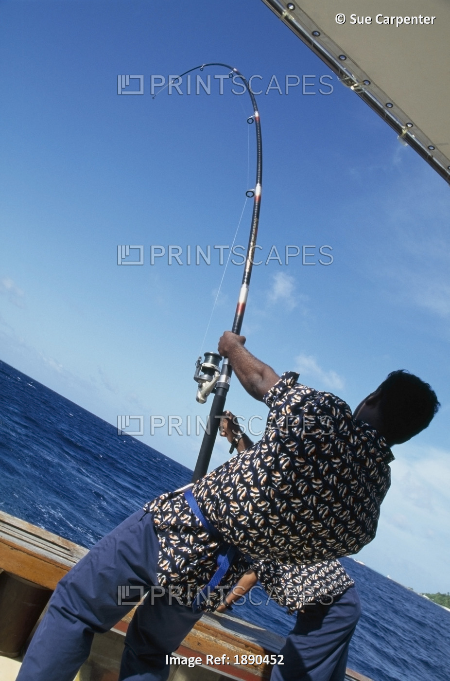Boatman With Fishing Rod Pulling In Catch