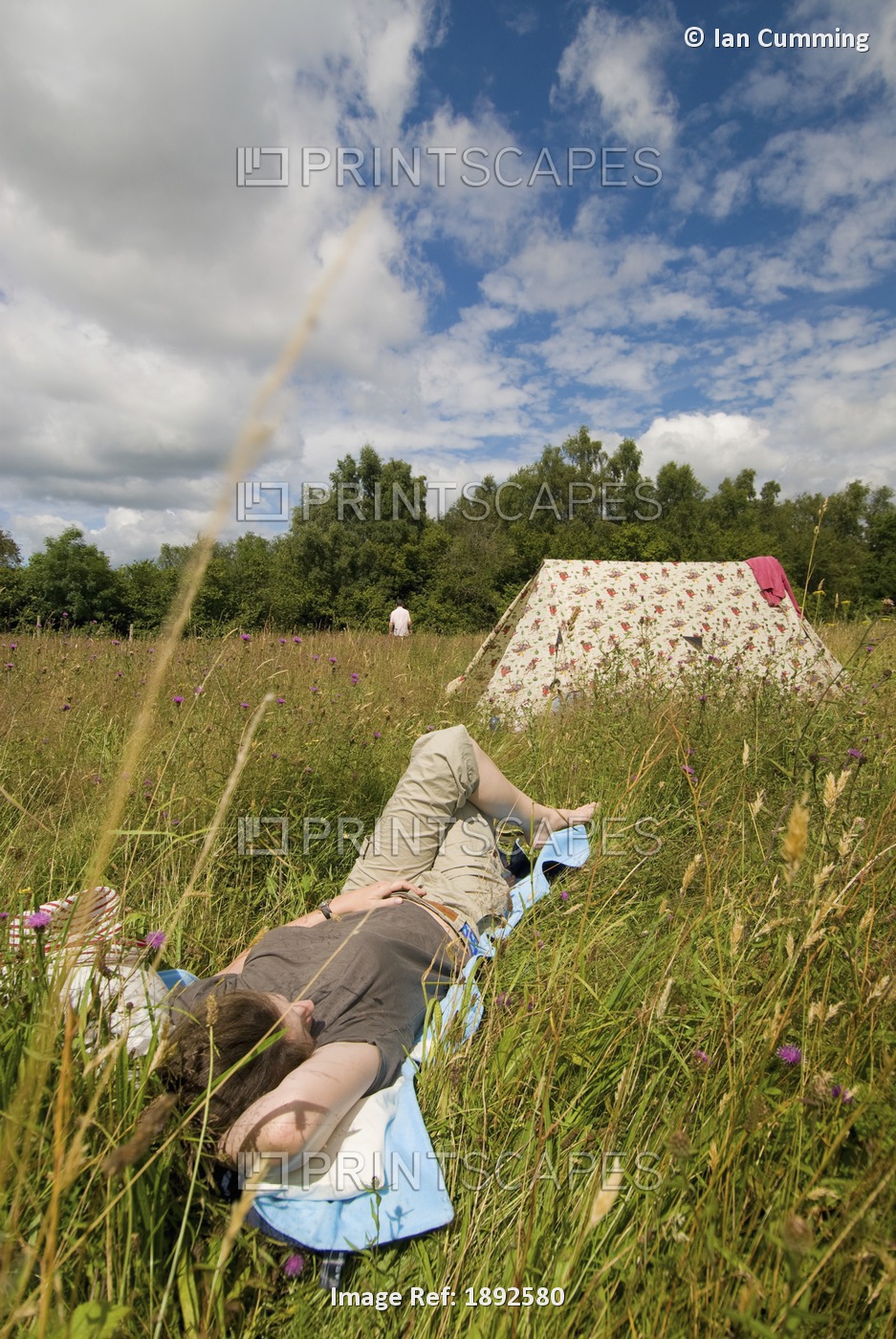 Woman Resting Beside Tent In Meadow