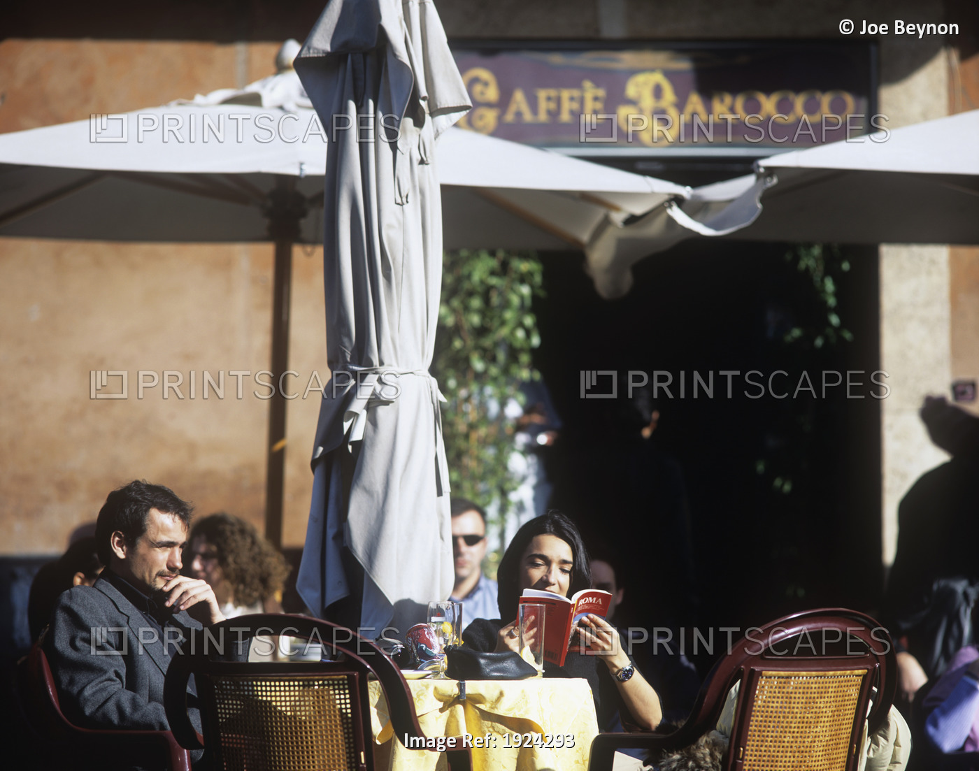 Italian Tourists At Cafe In Piazza Navona, Reading Guide Books