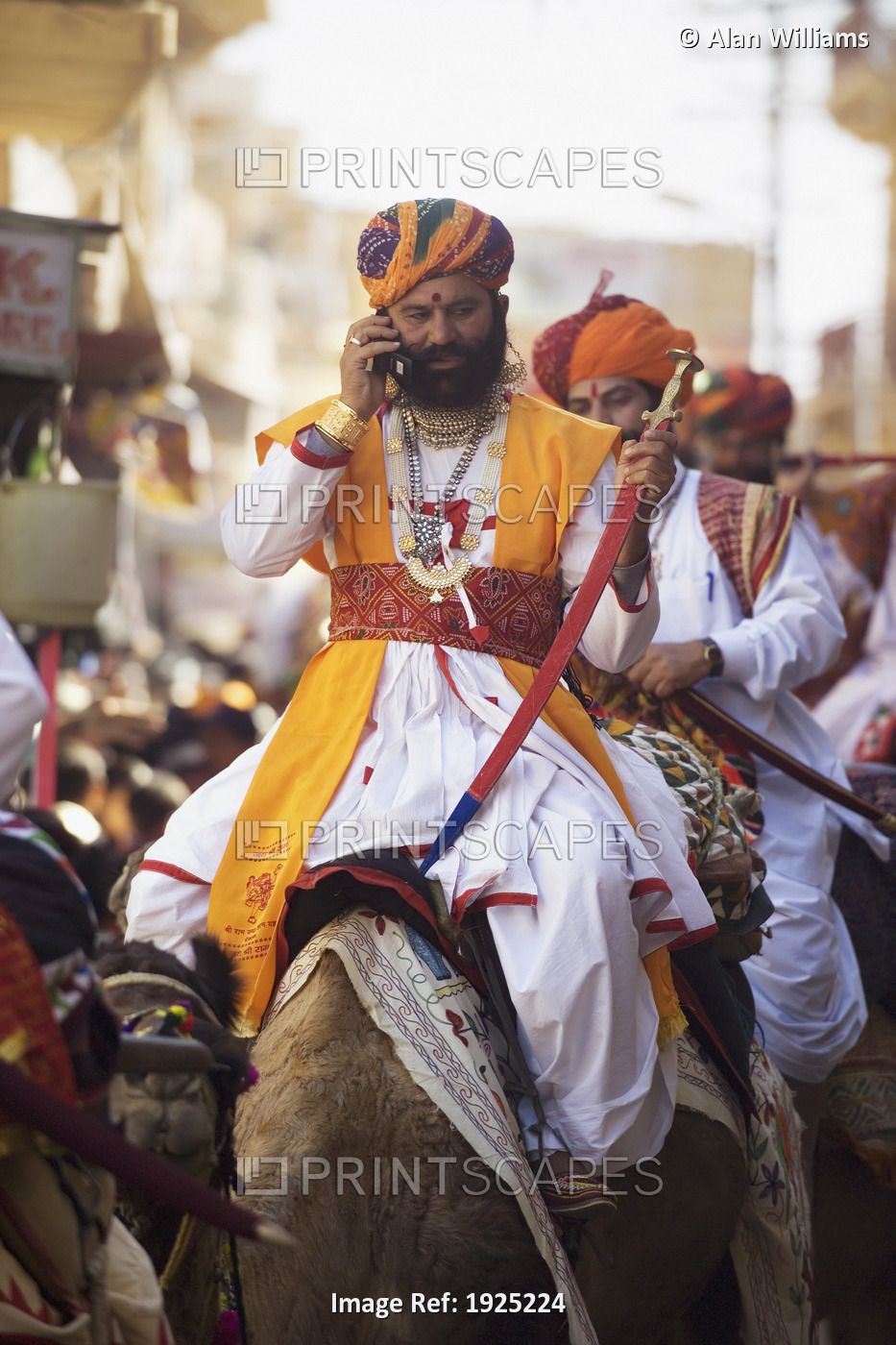 Man Riding Camel Using Cell Phone At Jaisalmer Festival, Rajasthan, India