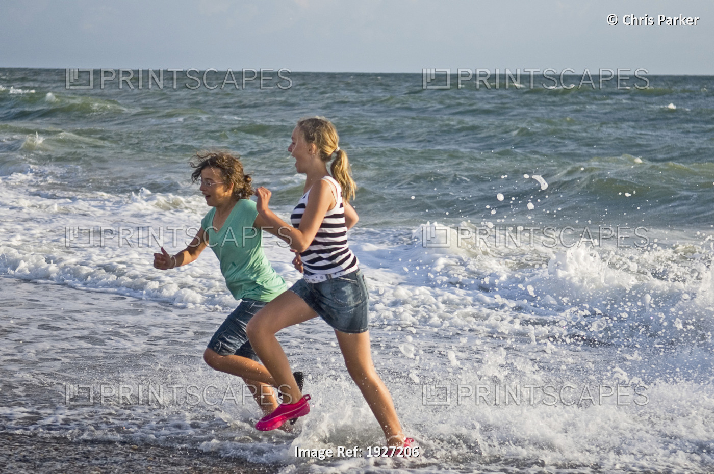 Girls Running In Waves On Beach, West Jutland, Denmark