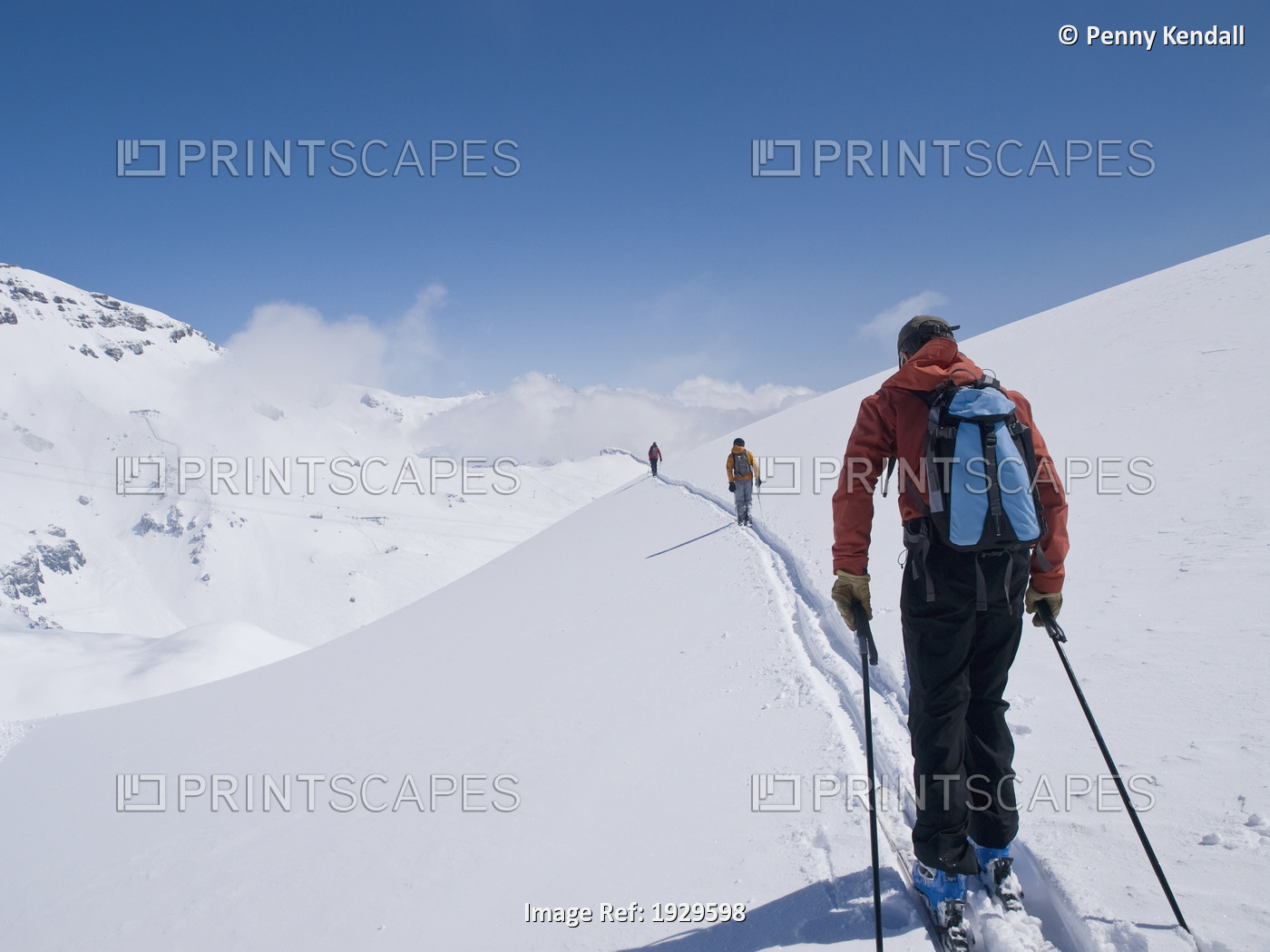 Three skiers traverse across a slope. Crans Montana, Valais. Switzerland. Model ...