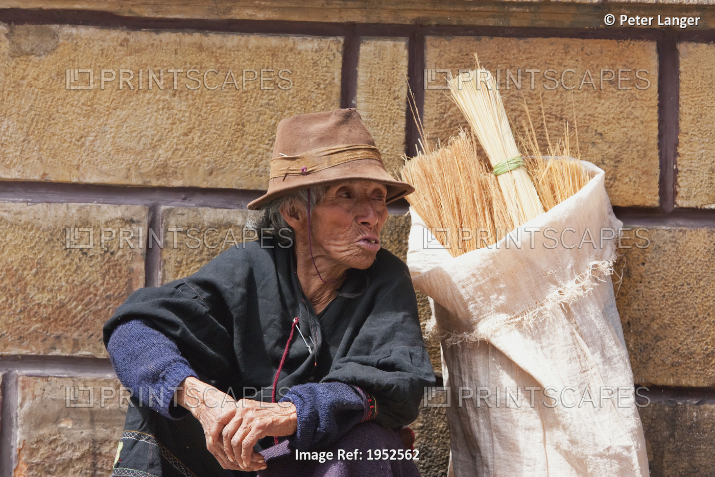 Broom vendor sitting against wall, Sucre, Chuquisaca Department, Bolivia
