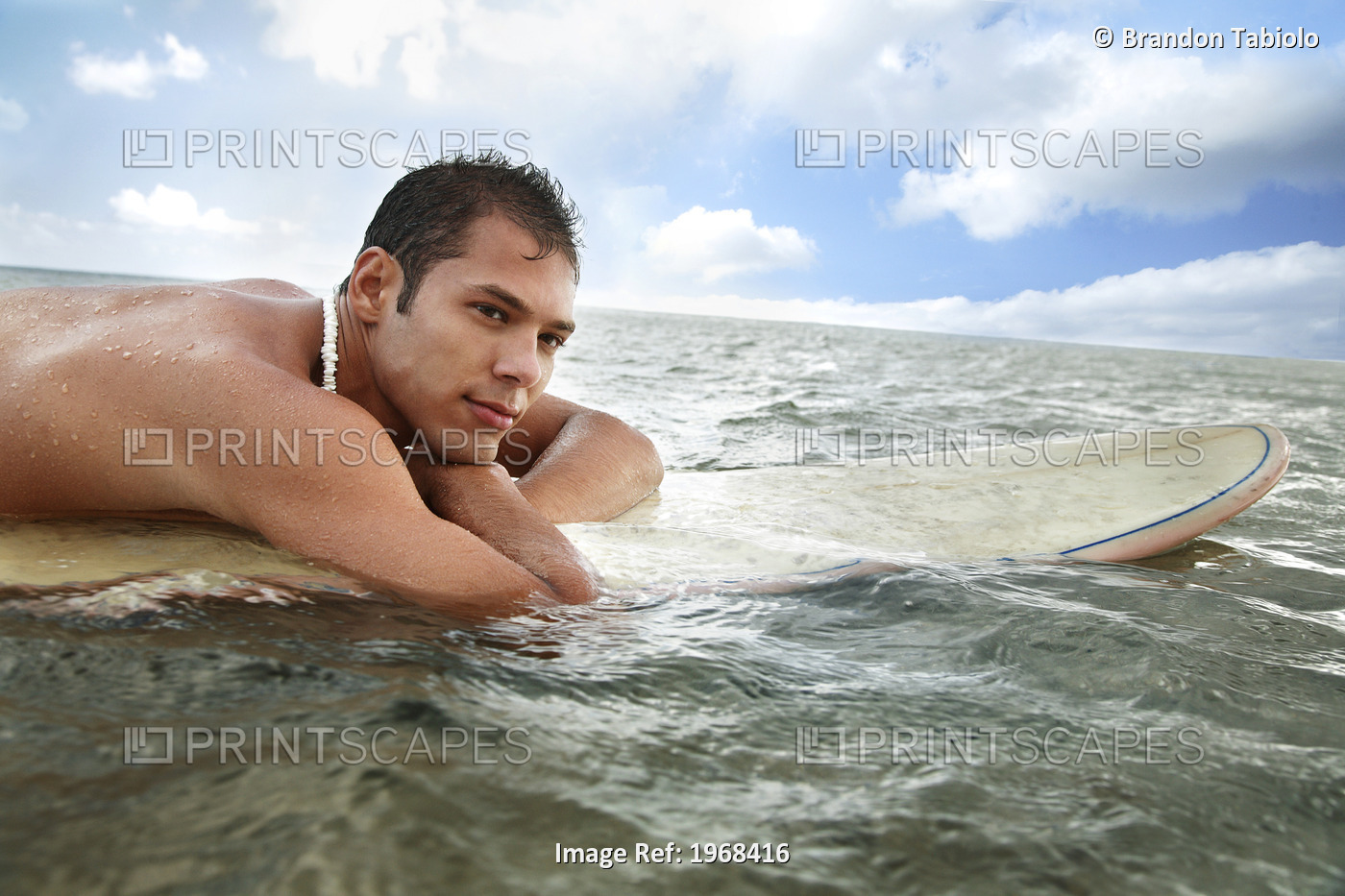 Hawaii, Oahu, Young Man Sitting On His Surfboard In The Water.
