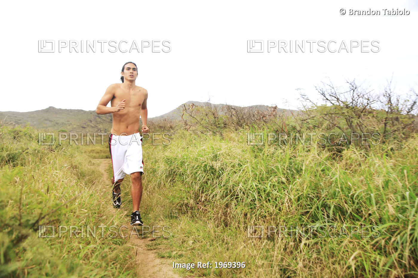 Hawaii, Oahu, Atheltic Male Jogging On An Outdoor Field Walkway Path