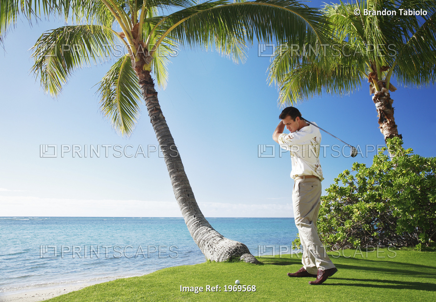 Hawaii, Oahu, Male Playing Golf, Ready To Swing His Golf Club At A Beach Front ...