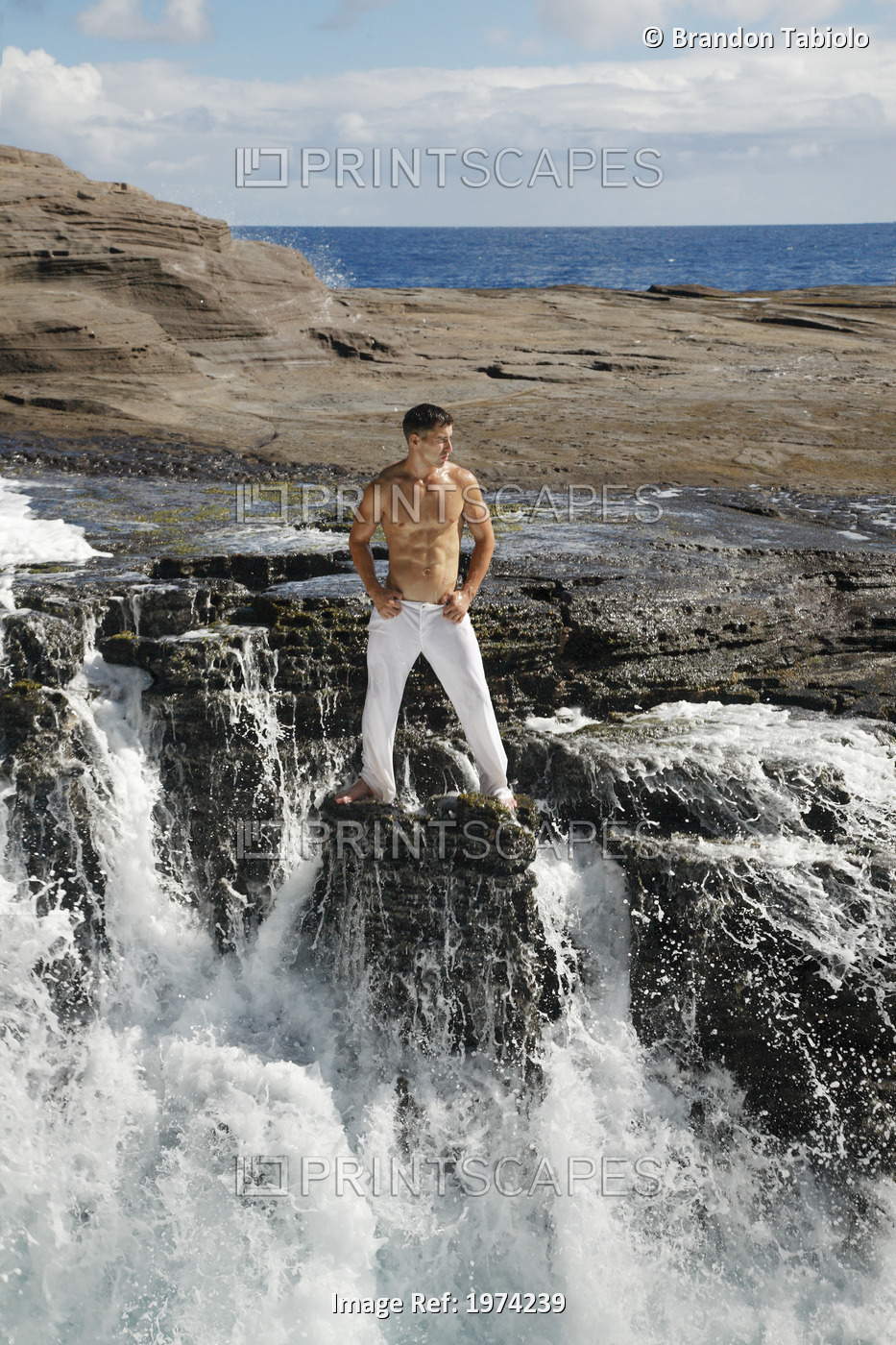 Hawaii, Oahu, Male Wearing White Pants On Rocky Cliff.