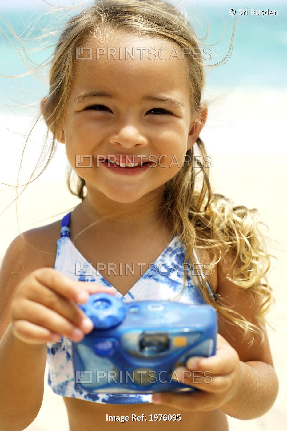 USA, Hawaii, Portrait of Little Girl Holding Cameraon beach ; Oahu