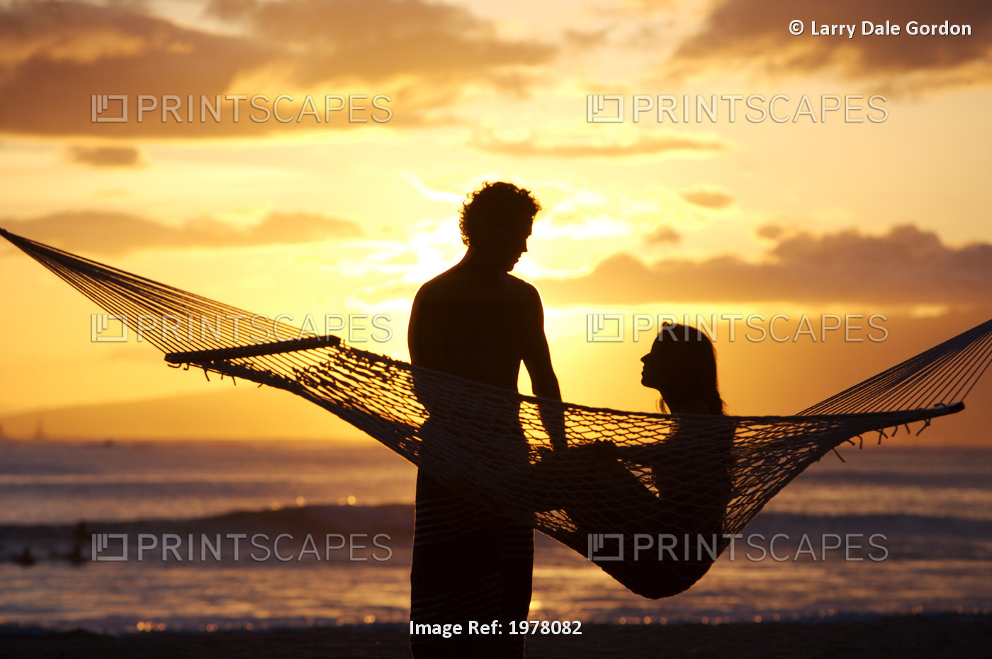 USA, Hawaii, Oahu, Silhouette of woman in hammock and man standing next to her ...