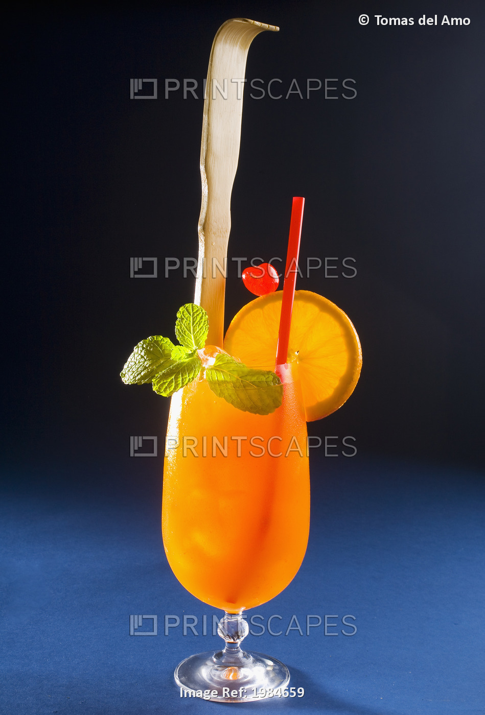 A Tropical Itch Cocktail Garnished With Fruit And A Backscratcher.