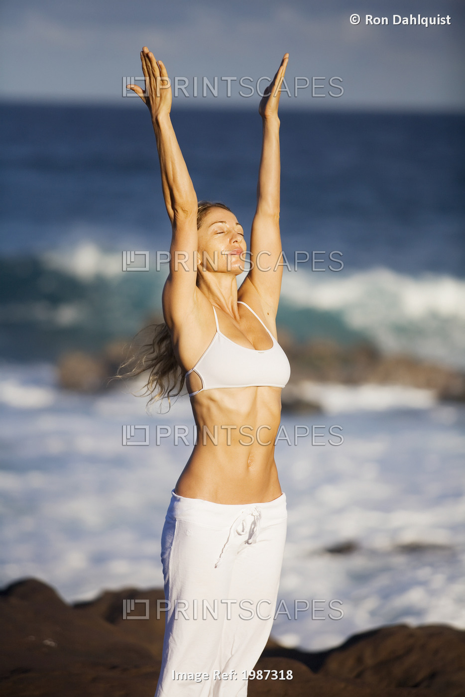 USA, Hawaii, Young woman doing yoga near Pacific Ocean; Maui