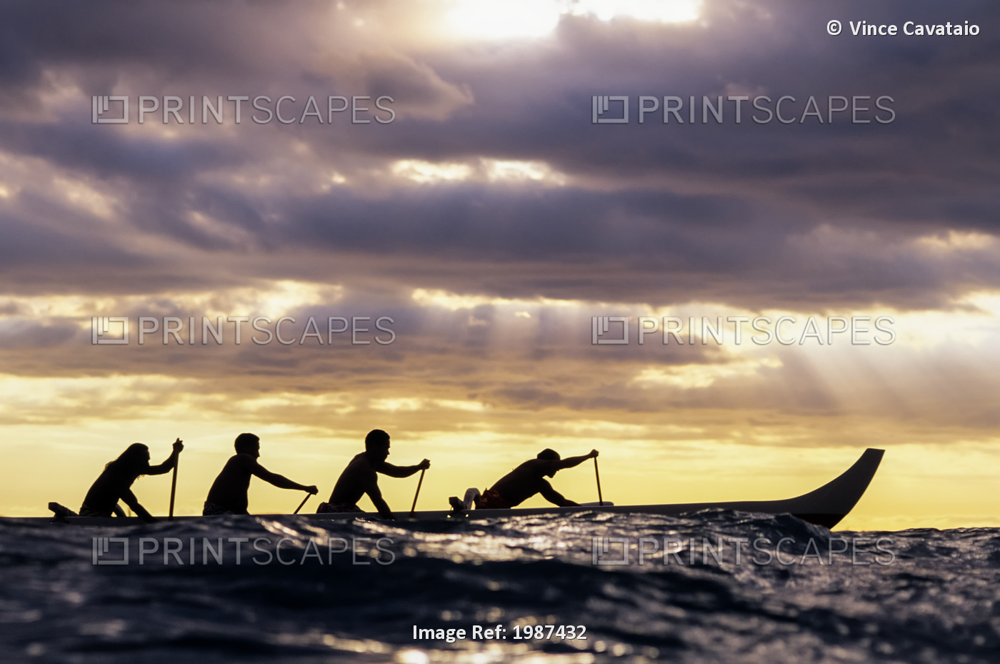 Outrigger Canoe And Paddlers Silhouetted At Sunset, Sunrays Through The Clouds