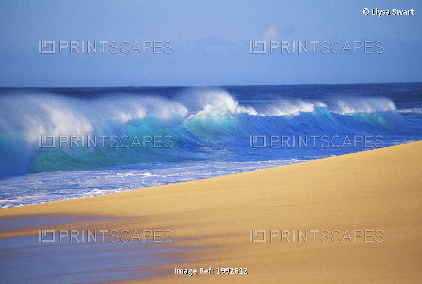 Shorebreak Waves Along Sandy Beach, Blue Sky