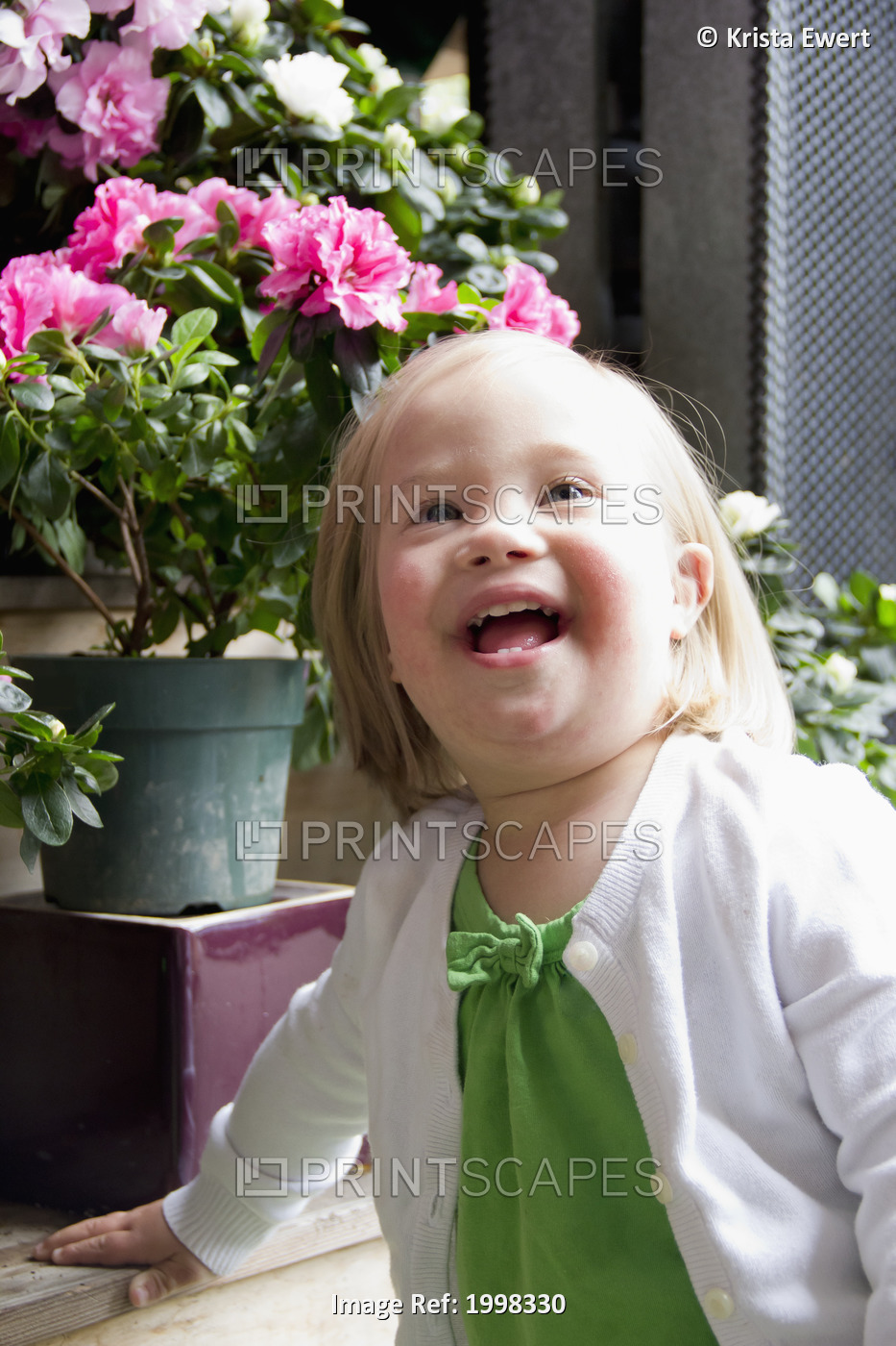 Portrait Of A Young Girl With Down Syndrome Beside Flower Pots; Vancouver, ...