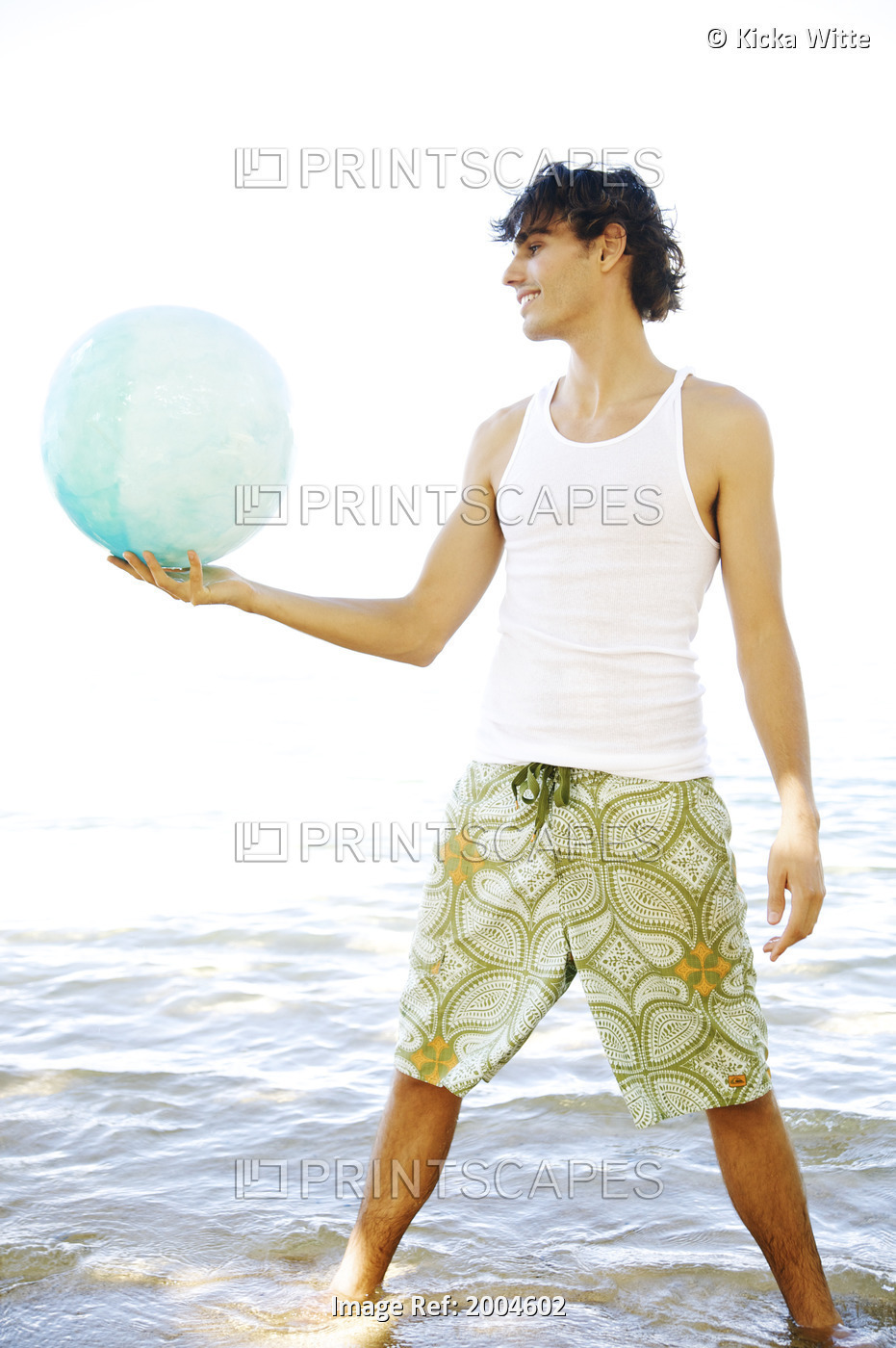 Hawaii, Kauai, North Shore, Handsome Guy Holds Ball While Standing In Ocean.