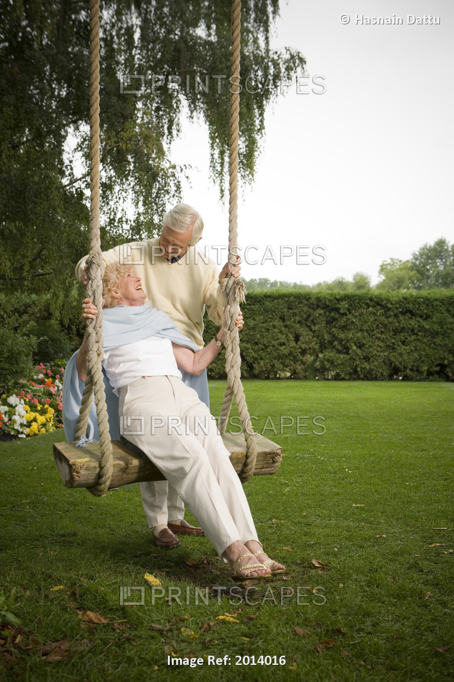Senior Man Pushing Woman On Swing