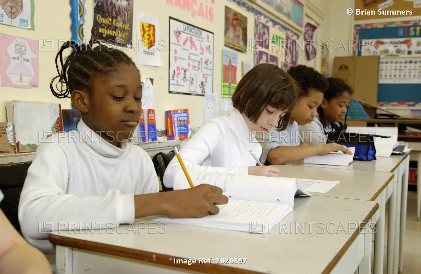 Multi-Ethnic Group Of Grade 5 Students Working At Their Desks In A Classroom