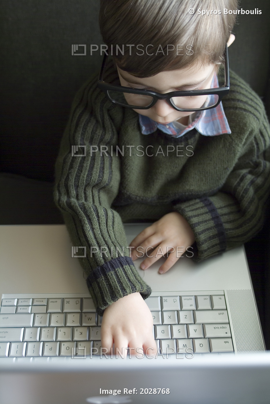 Little Boy With Large Glasses Typing On A Laptop Computer, Montreal, Quebec