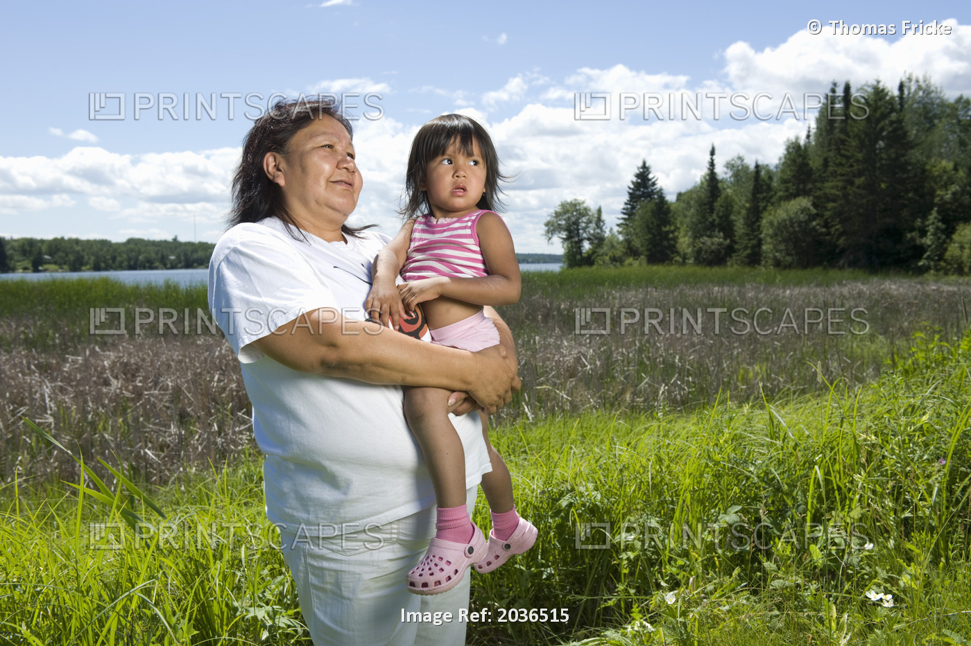 Native Aboriginal Grandmother Standing In A Field Beside A Lake With Her ...