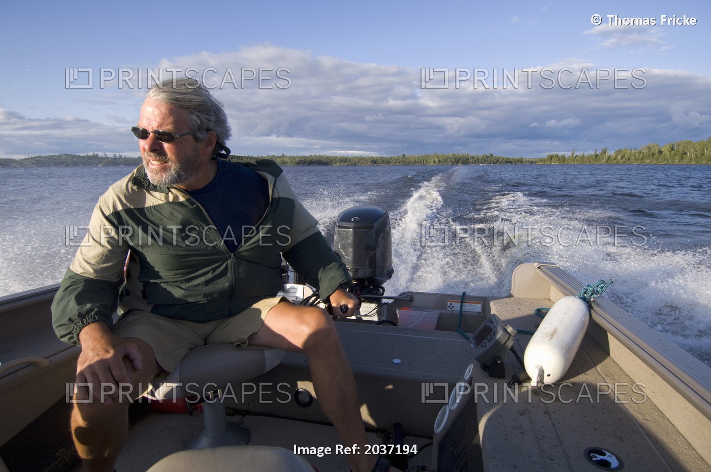 Man Driving A Small Fishing Boat On Gunn Lake, Ontario, Canada