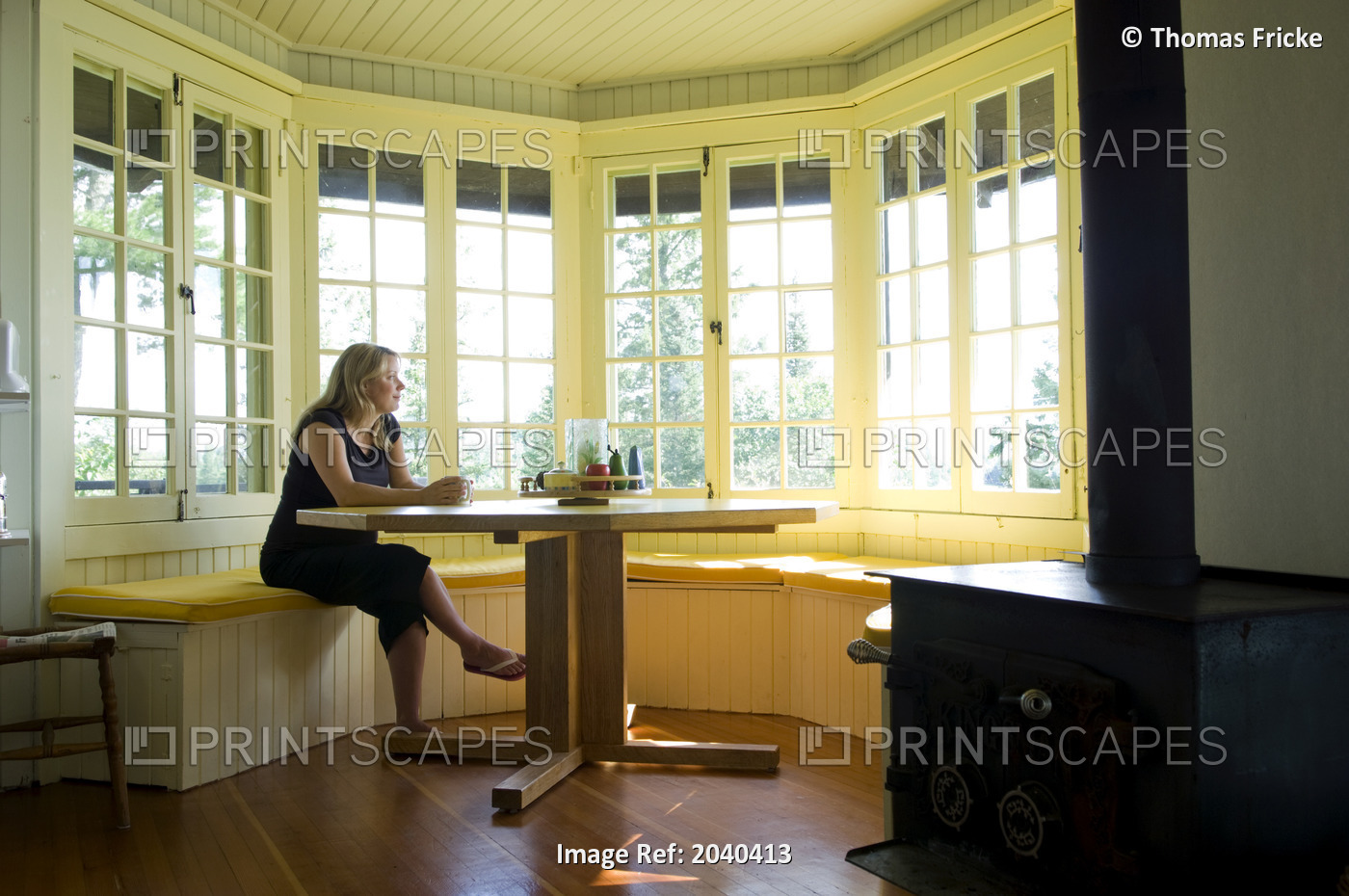 Woman Sitting At A Kitchen Table In A Cottage, Lake Of The Woods, Kenora, ...