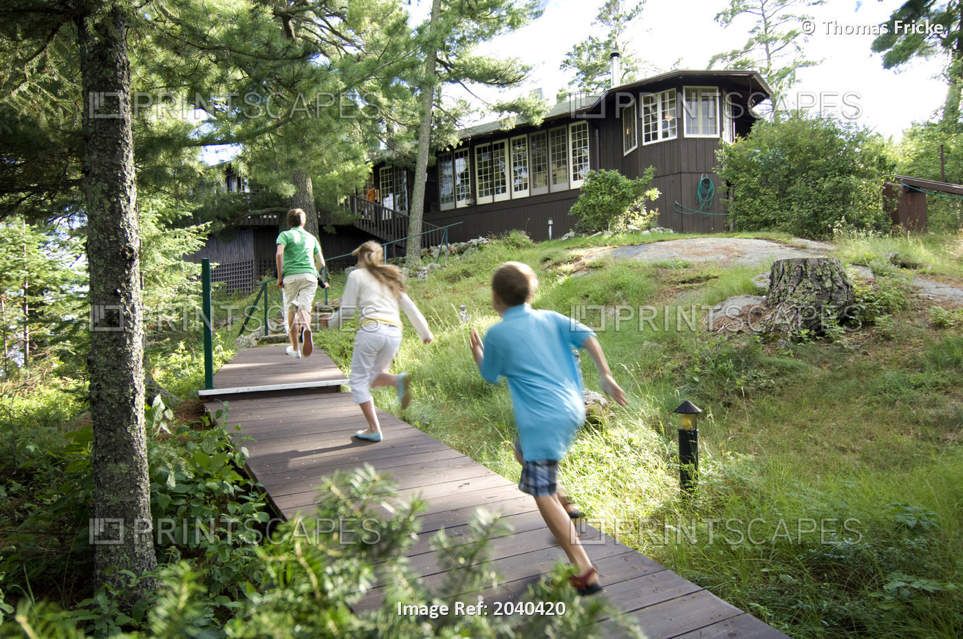Three Kids Running Up To A Cottage, Lake Of The Woods, Kenora, Ontario