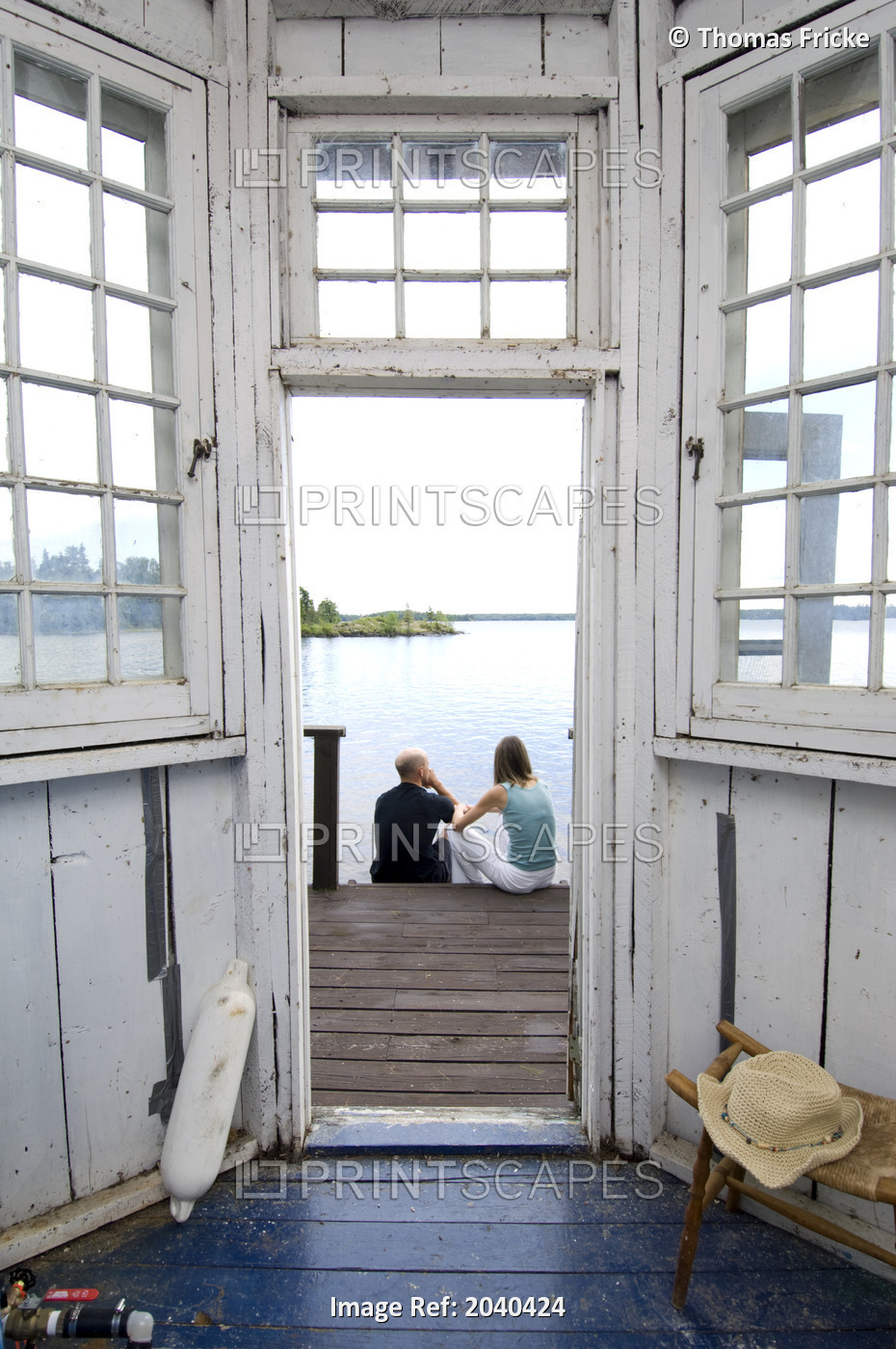View Through A Cottage Door With Couple Sitting On Steps, Lake Of The Woods, ...