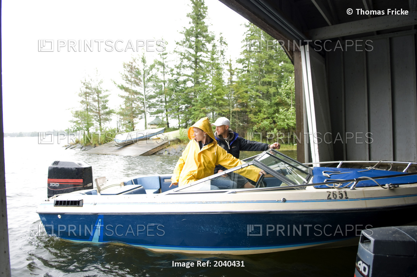 Couple Backing Out Of Boat House At A Cottage, Lake Of The Woods, Kenora, ...