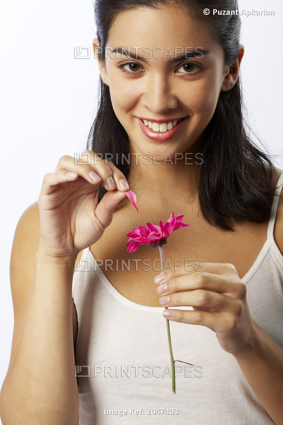 Woman Pulling Petal From Flower In Studio
