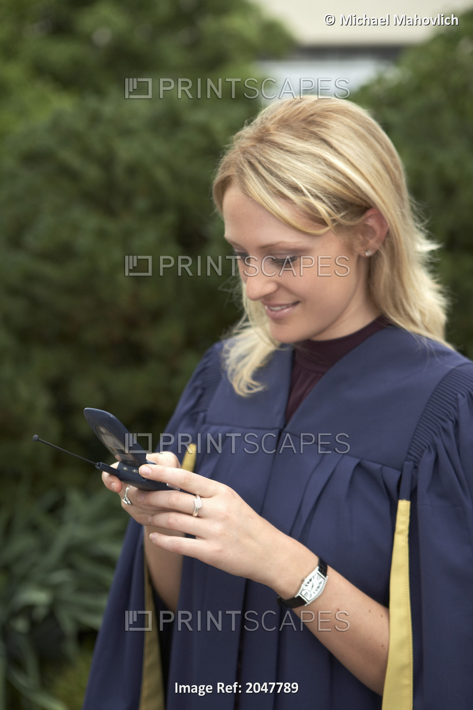 Woman In Graduation Gown Holding Cell Phone, Toronto, Ontario